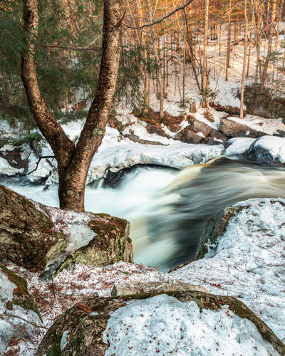 Stream flowing through rocks in winter