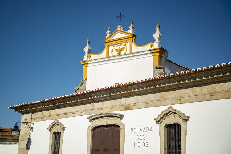 Low angle view of historic church against clear blue sky