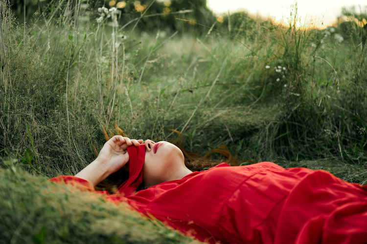 MIDSECTION OF WOMAN LYING DOWN ON FIELD