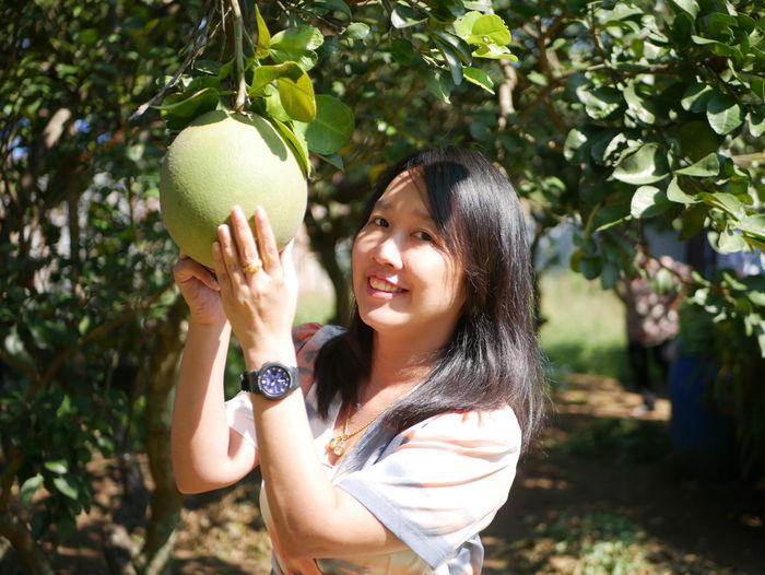 Young woman holding grapefruit