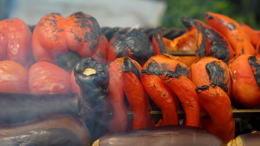 Red peppers, tomatoes, sweet peppers and eggplants are cooked on coals on grill. vegetables 