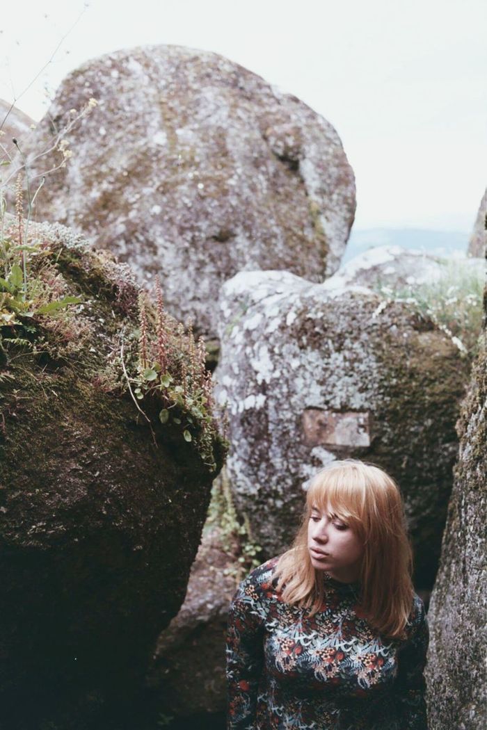 High angle view of young woman standing against rock formations
