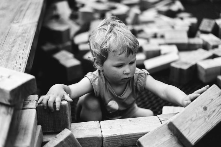High angle view of cute baby girl sitting amidst wood