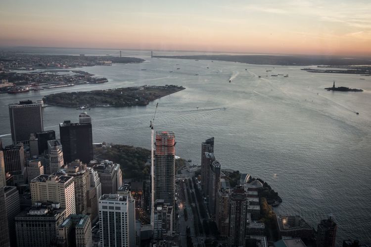 Aerial view of city and hudson river against sky during sunset