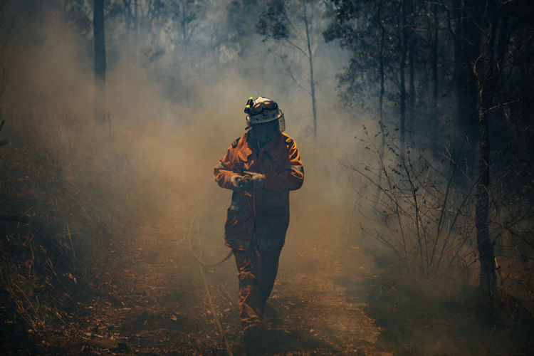 A firefighter with a hose during a large wildfire in austalia