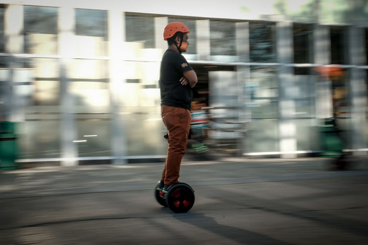 Blurred motion of man riding electric unicycle on street