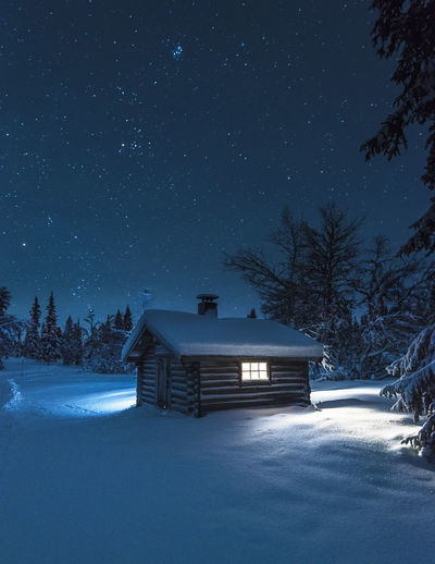 Illuminated log house at night
