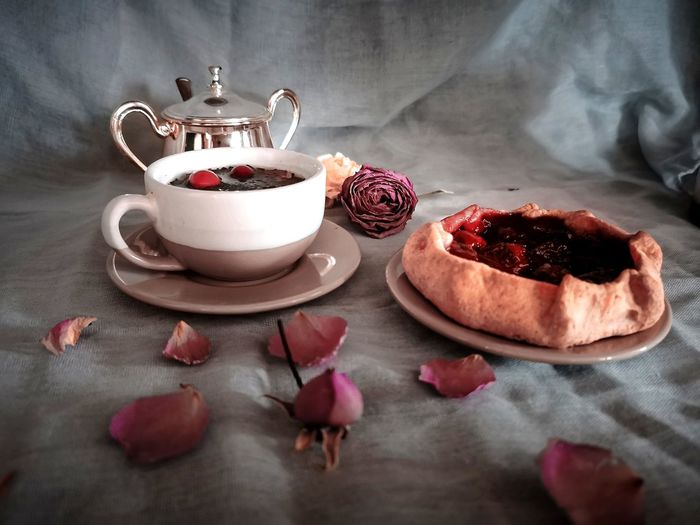 Close-up of roses in cup on table