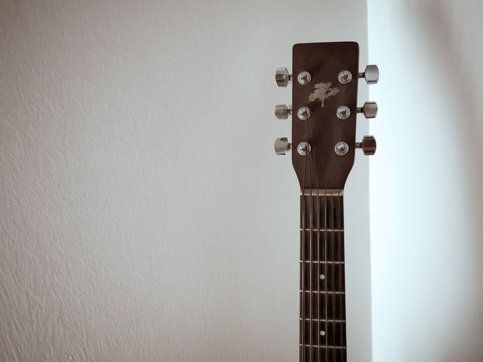 Close-up of guitar against wall