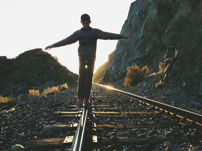 Man on railroad track against sky