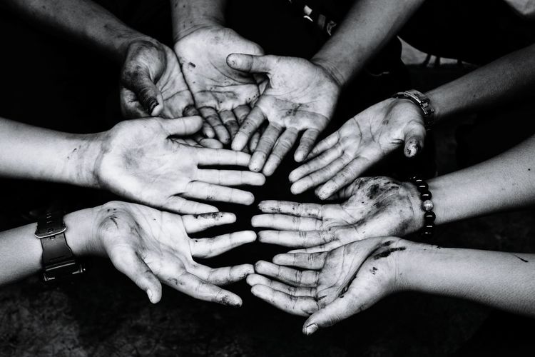 Cropped image of friends showing dirty hands