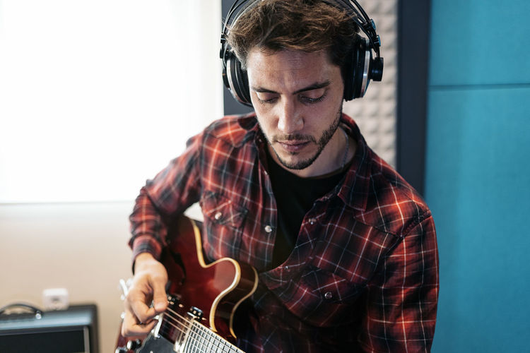 Singer playing guitar at studio