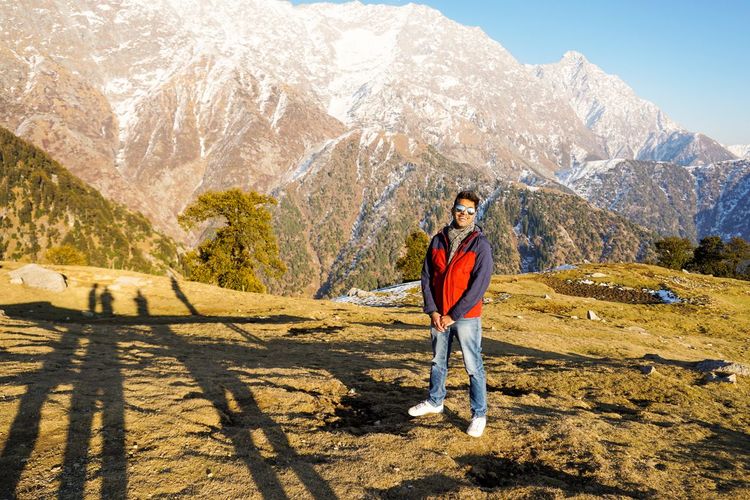 Portrait of man standing against mountain range