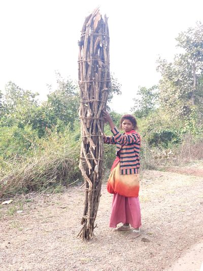 Full length of woman standing by tree on field