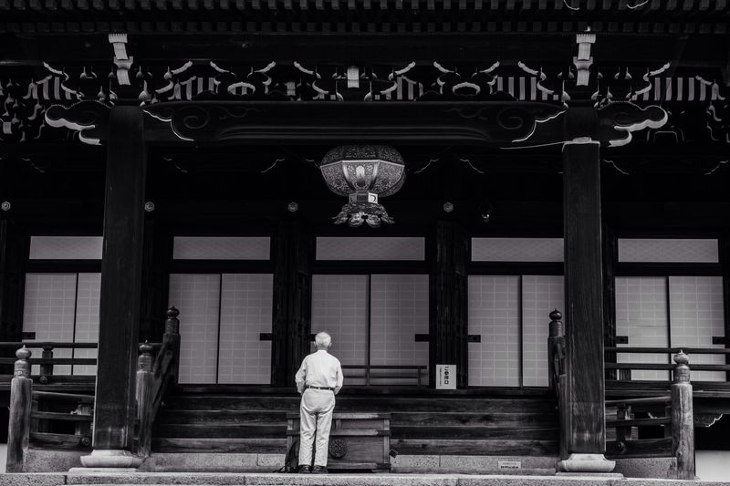 Old men praying outside temple