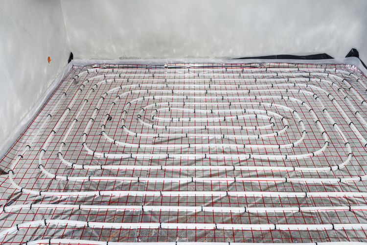 White pipes of underfloor heating systems, distributed in an individual family house on  foil.