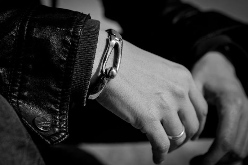 Midsection of man wearing bracelet and leather jacket