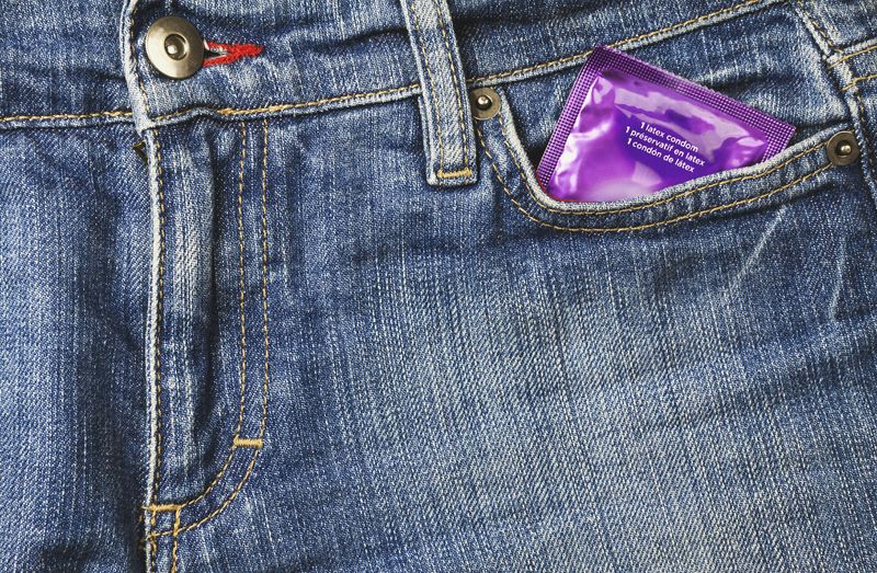 Close up of condom in denim jeans pocket
