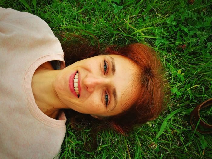 Portrait of a smiling young woman lying on grass