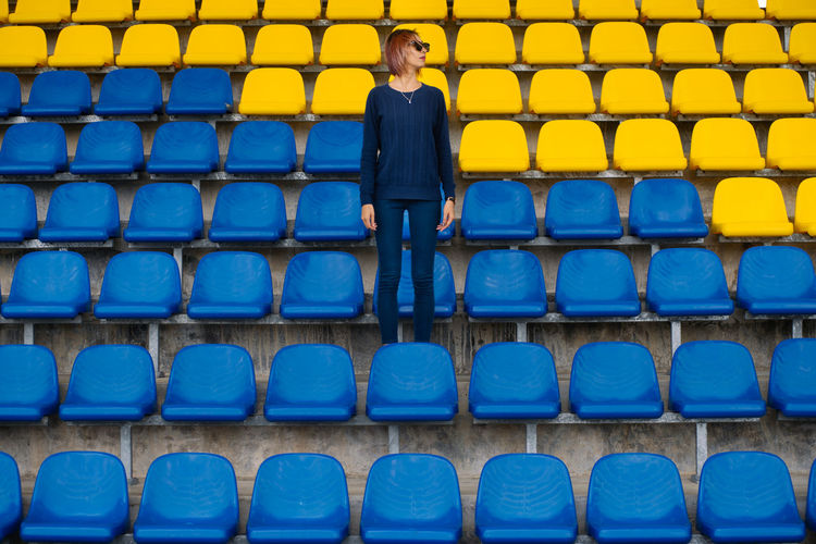 Woman standing by seats at stadium