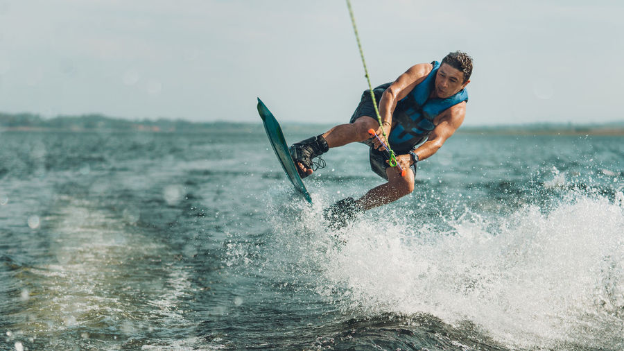 Man surfing on sea against sky