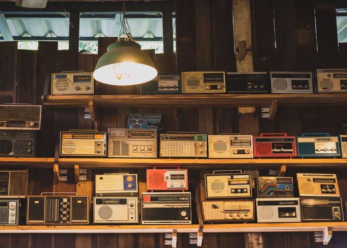 Old radios on shelf in illuminated room