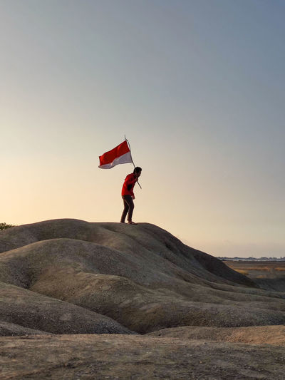 Low angle view of man jumping against clear sky