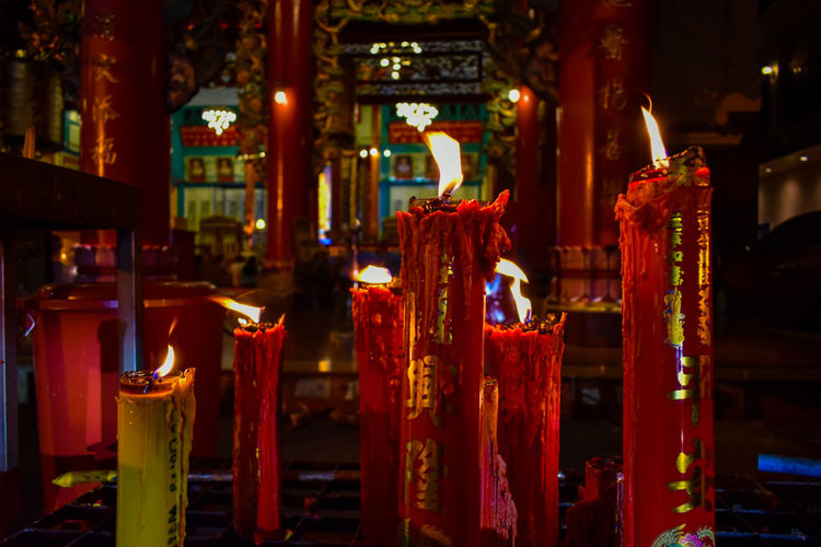 Panoramic view of illuminated candles in temple
