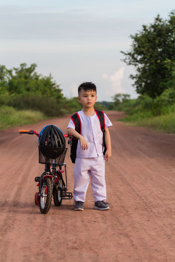 Boy riding motorcycle on road against sky