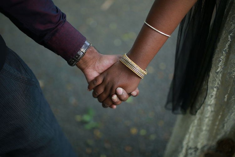  couple holding hands while standing outdoors