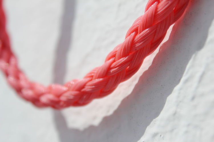 Close-up of orange rope against wall