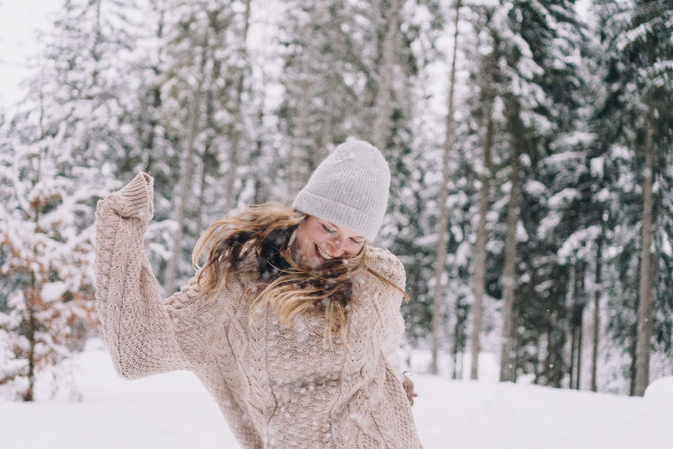 Portrait of smiling woman with snow covered tree