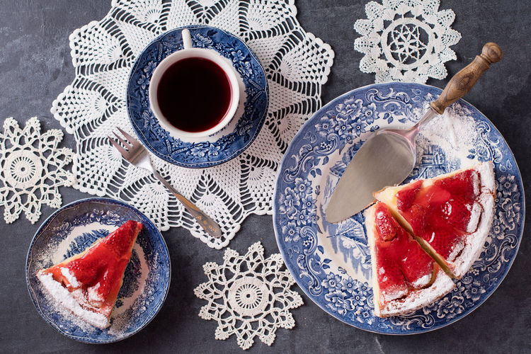 Christmas red strawberry pie on blue plates and a gift in a red box on the table