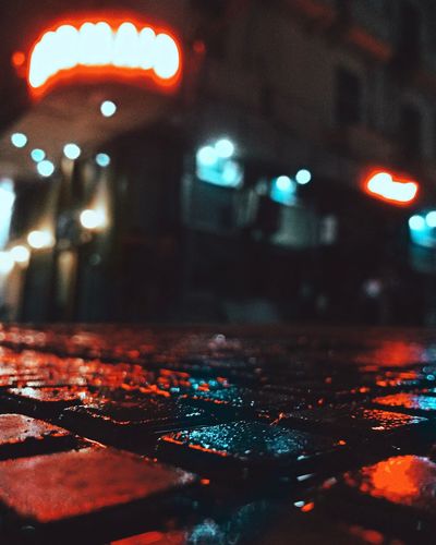Close-up of illuminated wet street