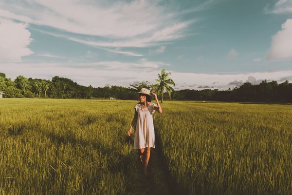 Woman standing on field against sky