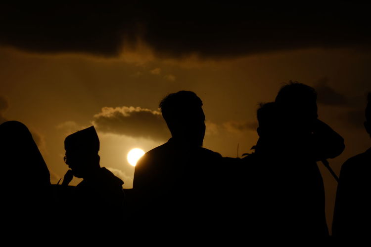 Silhouette people against sky during sunset