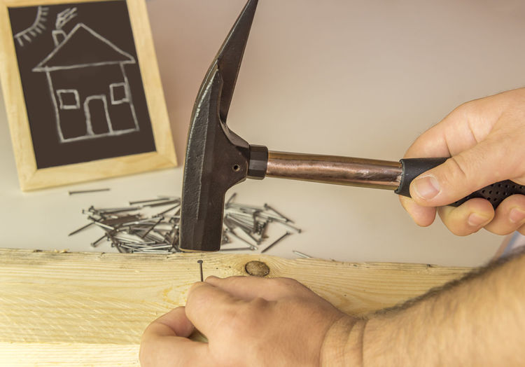 Cropped image of carpenter hammering nail on wood