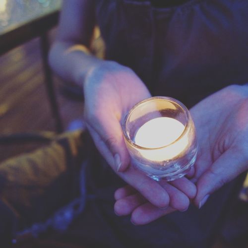 Close-up of hands holding a candle