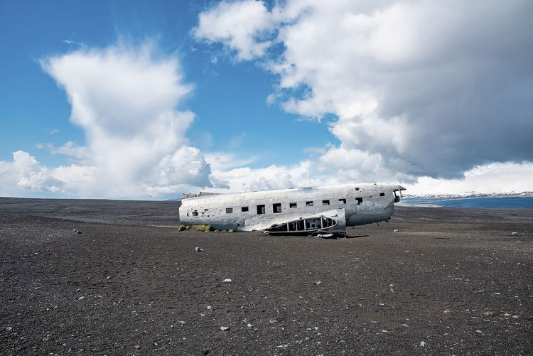 Broken military airplane wreck at black sand beach in solheimasandur against sky