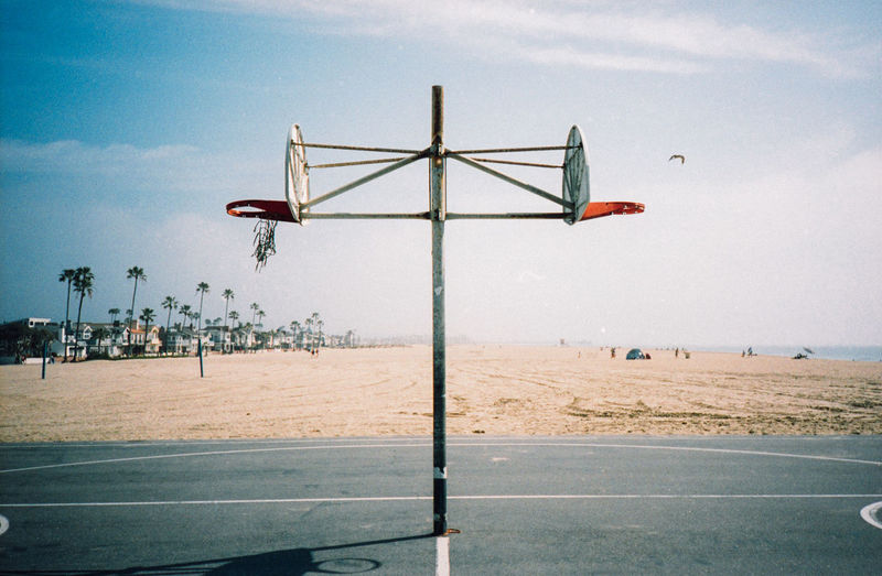 Basketball hoop at beach against sky