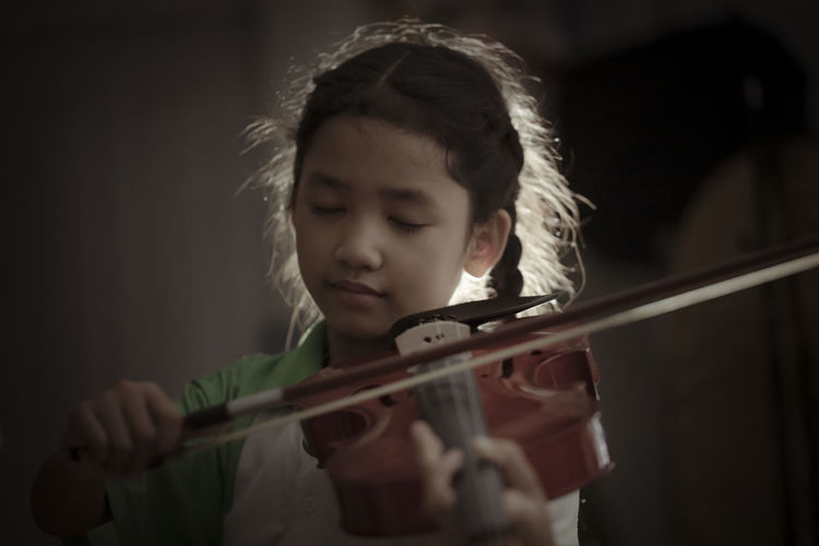 Girl playing violin indoors