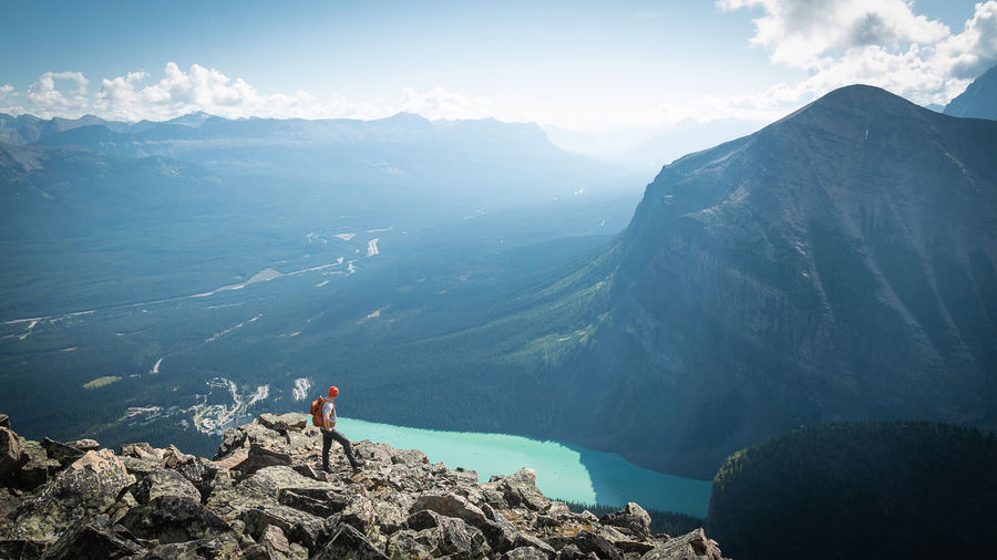 Hiker on the top of mountain enjoying views on glacial valley and lake