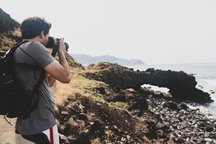 Male photographer at ka'ena point on oahu, hawaii