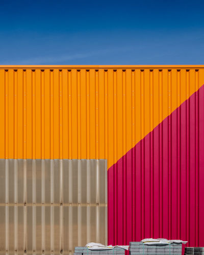 Multi colored wall against clear blue sky
