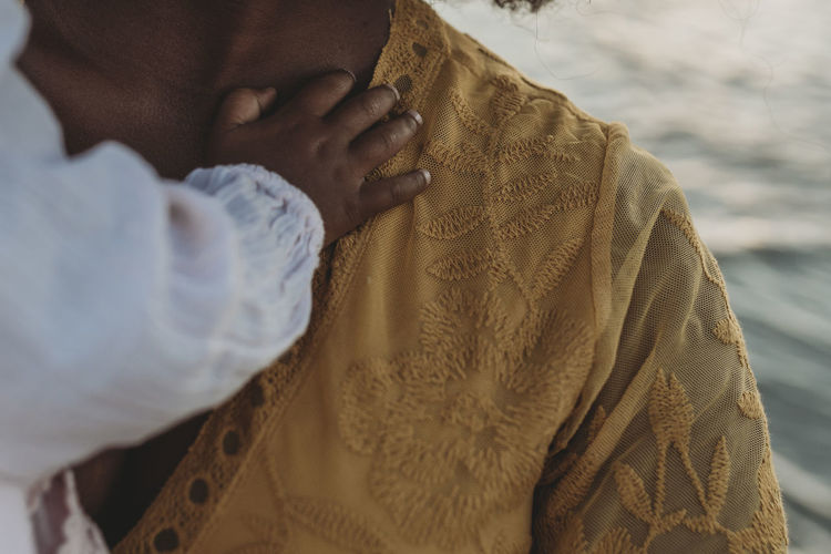 Close up detail of daughters hands embracing mother
