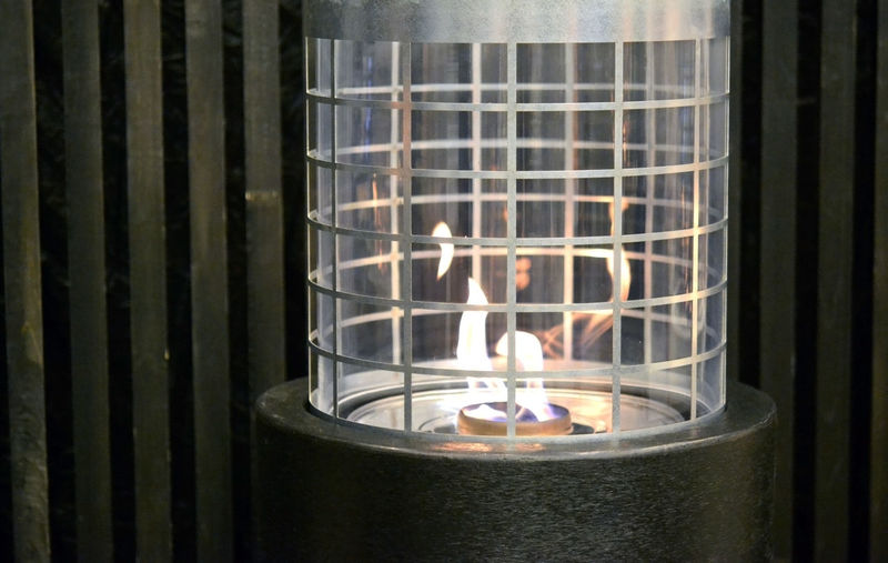 Close-up of lit candles on metal grate