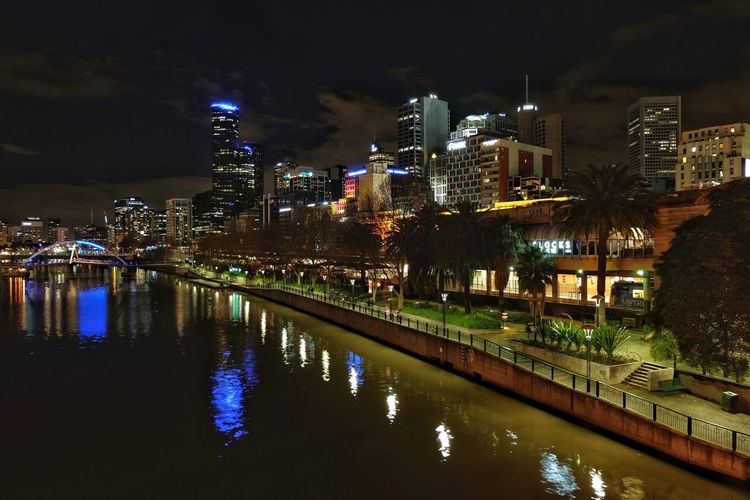 Illuminated buildings by river against sky at night, melbourne australia 