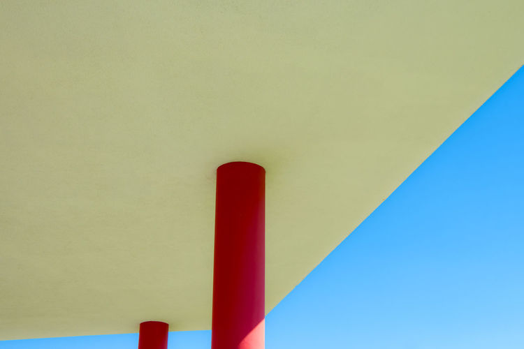 Low angle view of red column in building during sunny day