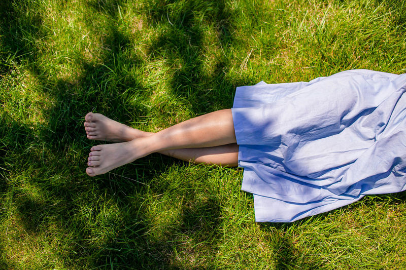 Female bare feet on green grass in summer