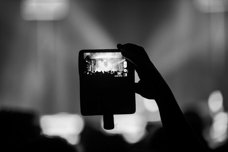 Cropped image of person recording dj concert on smart phone